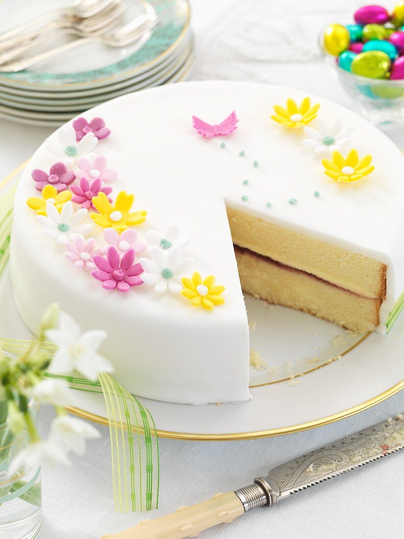 An Easter cake with white icing and sugar flowers