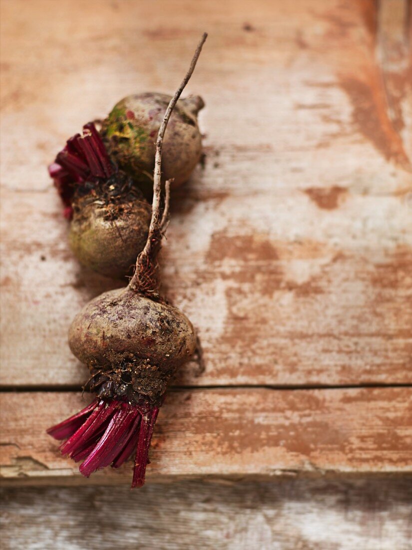 Three organic beetroots on a wooden surface