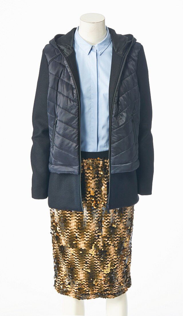 A light blue blouse and a brown sequinned skirt with an open quilted anorak