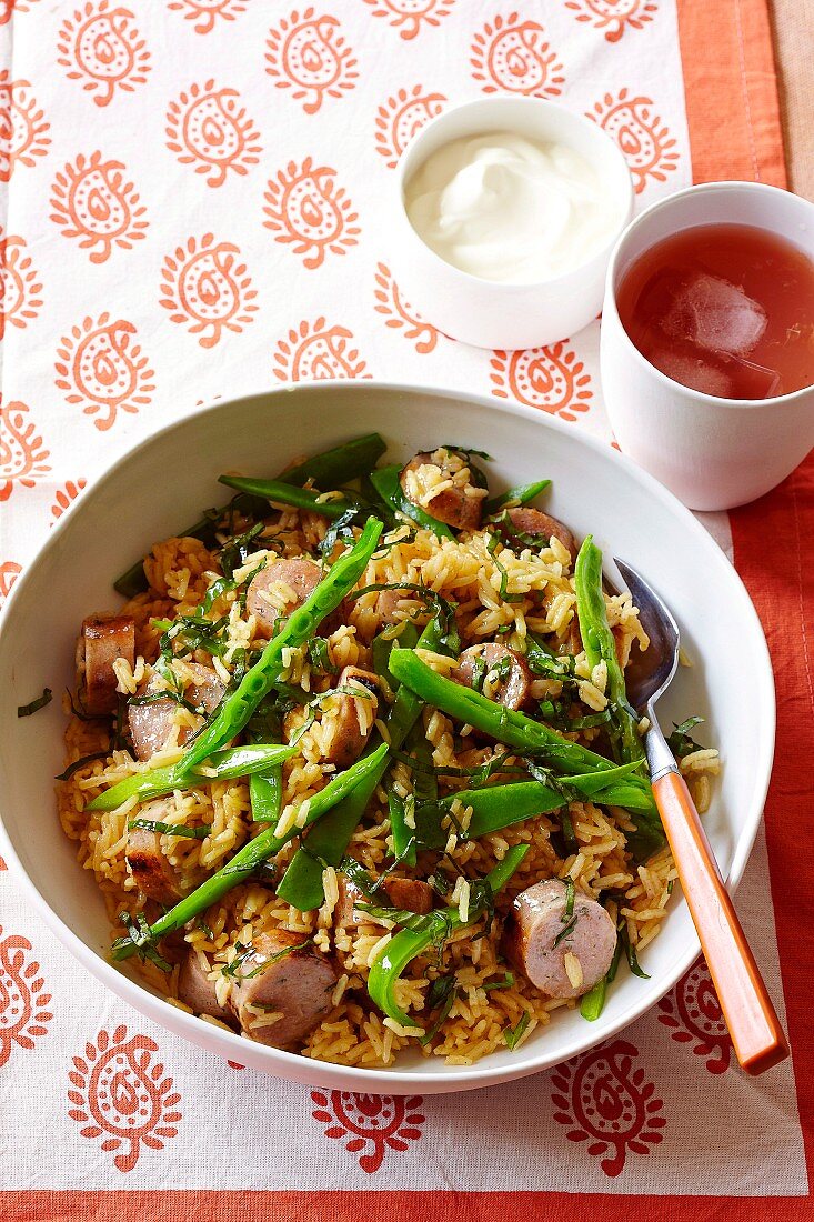 Curry pilaf with chicken sausages, sugar snap peas and basil