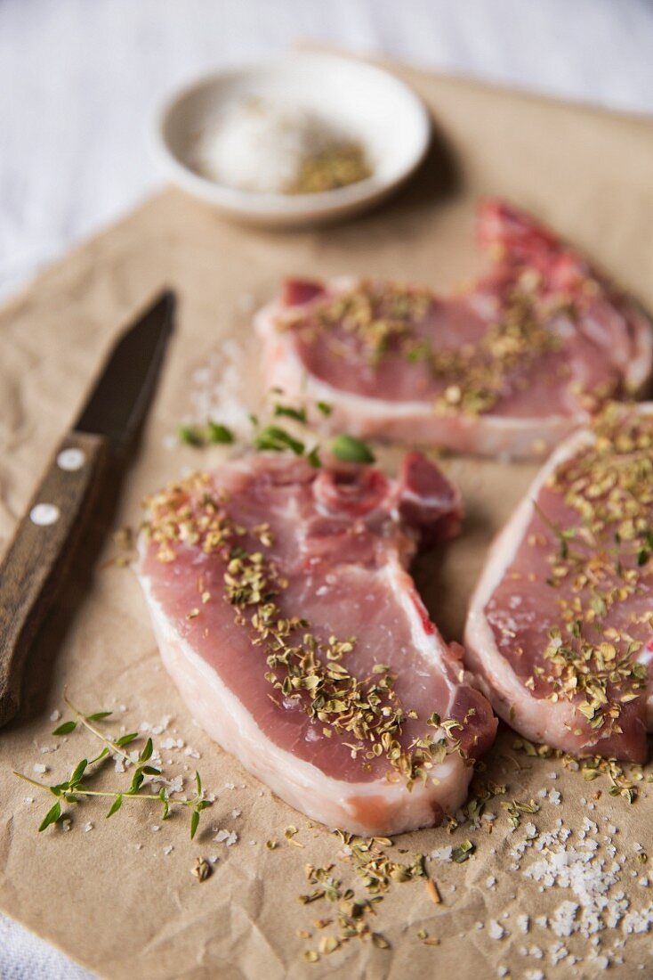 Raw pork chops with various seasonings