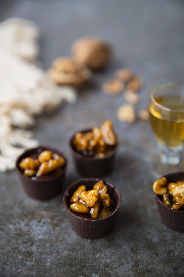 Chocolate cups with caramelized walnuts served with liqueur