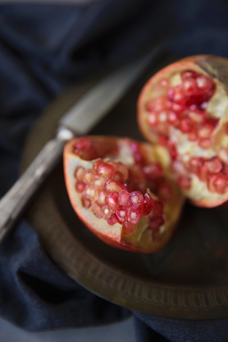 A sliced pomegranate on an antique plate