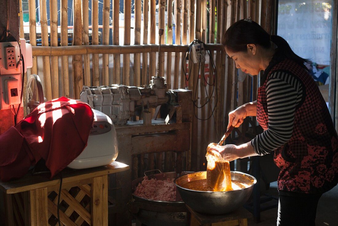 A woman making Thai sausages