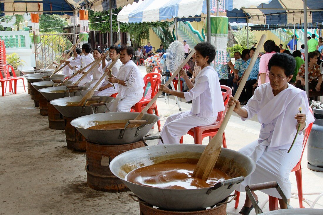 Thailändische Frauen in weissen Kleidern bei der Zubereitung von traditionellem, süssen Reis