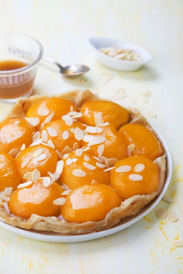 Tarte tatin with peaches, flaked almonds and maple syrup