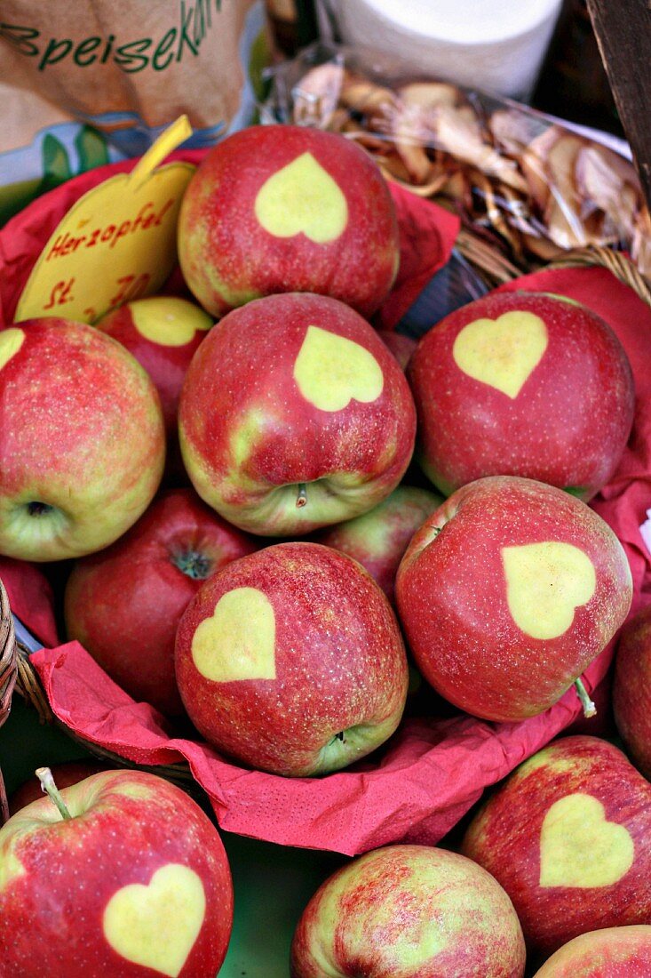Red apples stencilled with hearts at a market
