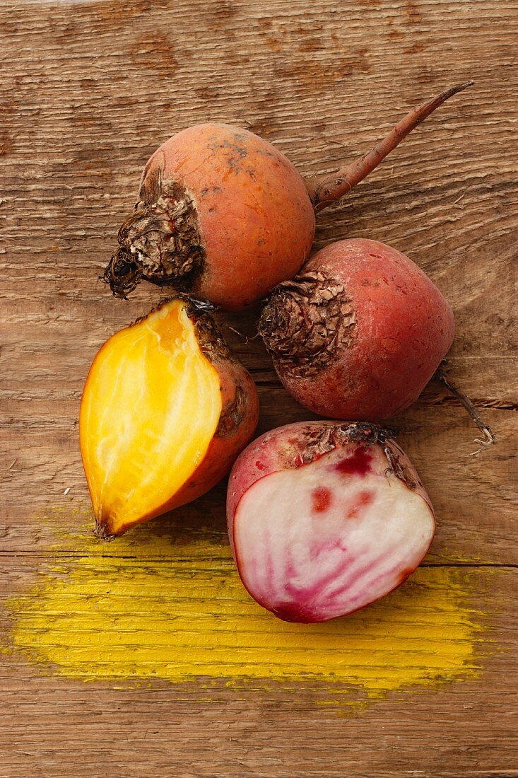 Beetroot and yellow beets on a wooden surface