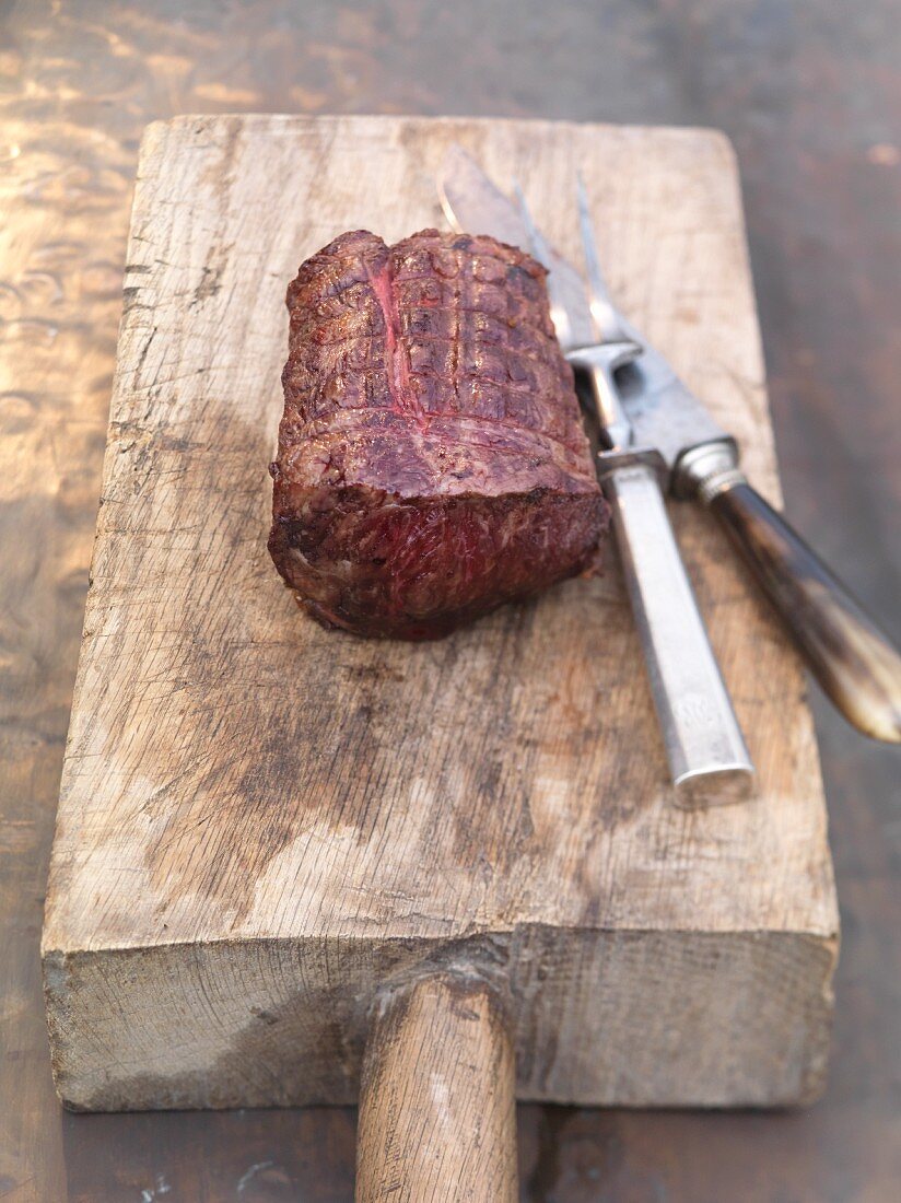 Roast beef on a rustic wooden chopping board