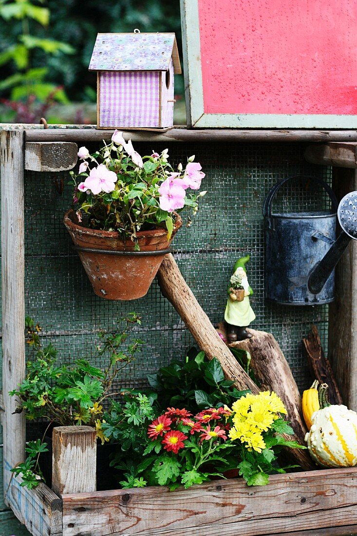 Pflanztisch dekoriert mit Blumen, Giesskanne & Vogelhäuschen