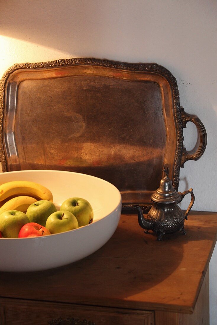 White fruit bowl and tray on top of cabinet