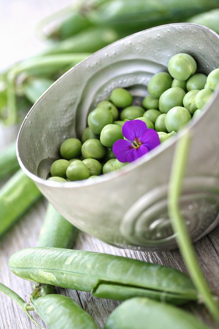 A bowl of peas with purple flower