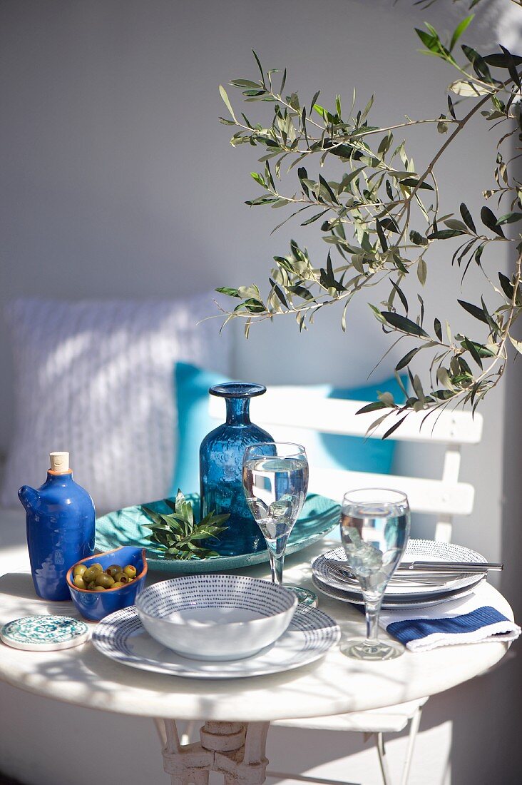 Gedeckter Tisch mit Geschirr in Blau und Weiß auf der Terrasse