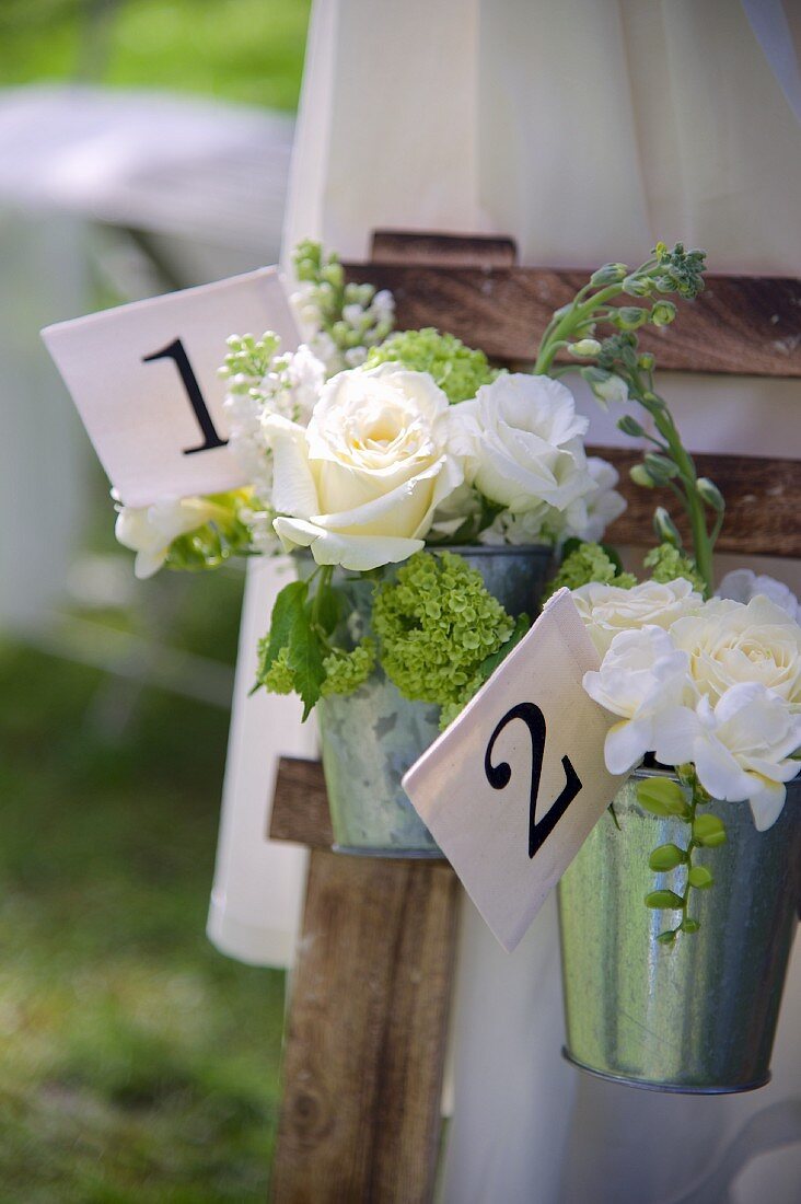 Zinkkübel mit weissen Rosensträussen und Schild mit Nummer