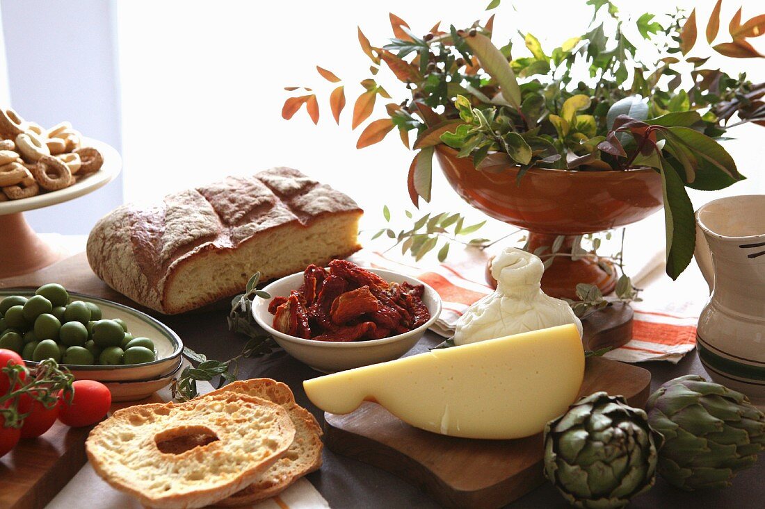 Apulisches Stillleben mit Käse, Brot, Gebäck und Gemüse