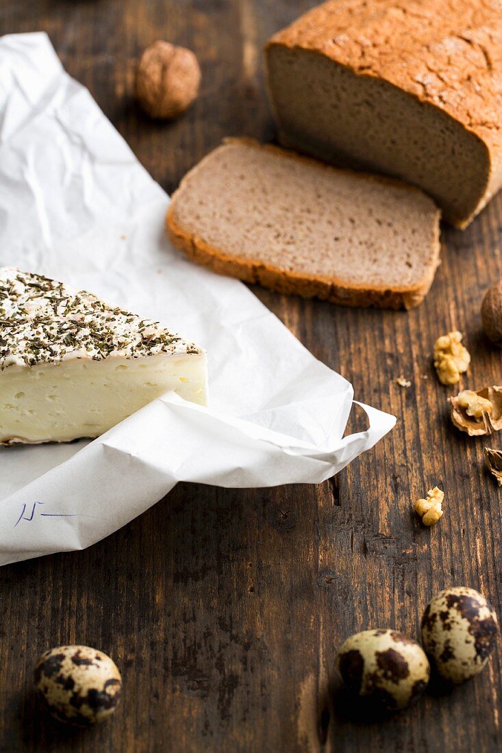 Glutenfreies Brot, Ziegenkäse mit Kräutern, gekochte Wachteleier und Nüsse