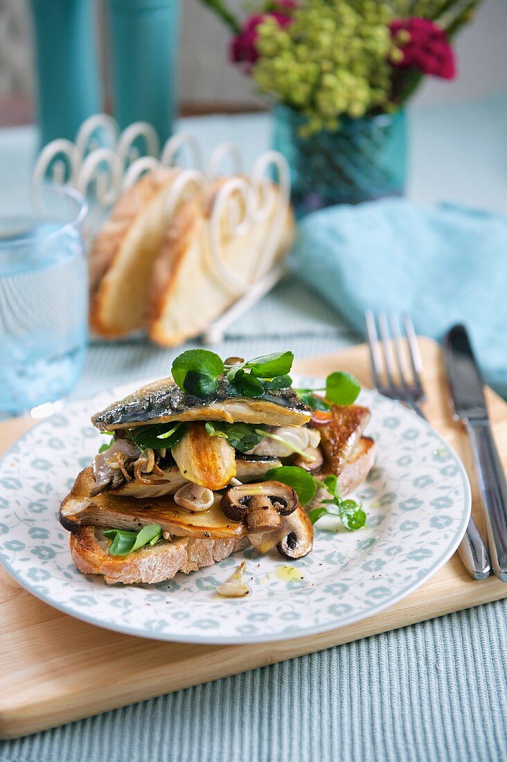 A slice of bread topped with mackerel and mushrooms