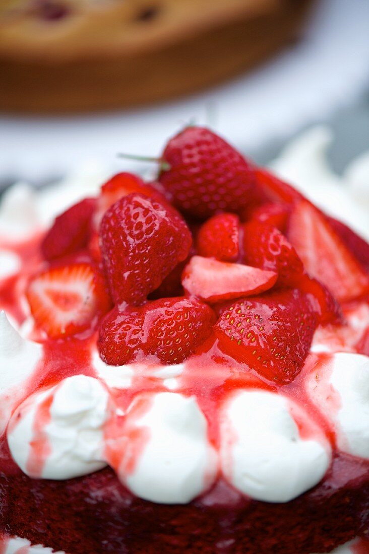 A slice of strawberry cream cake on a cake buffet