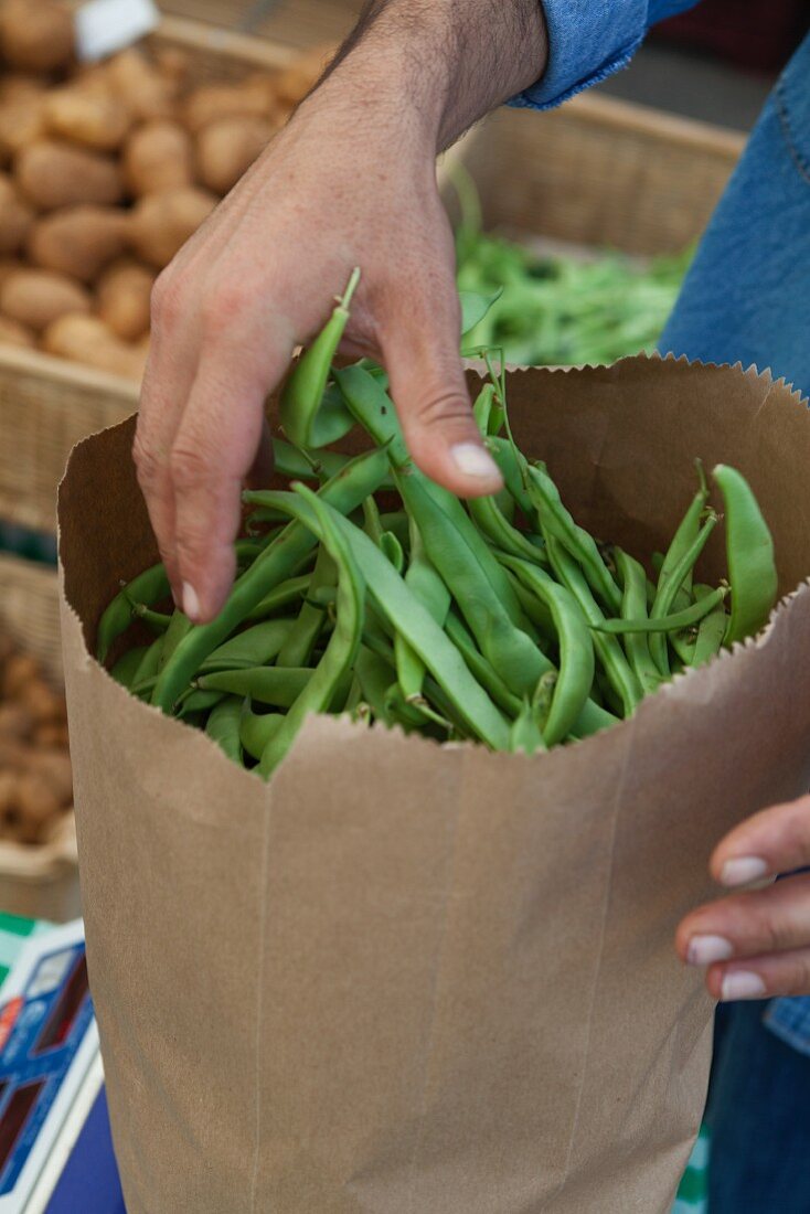 Green beans in a paper bag at a market