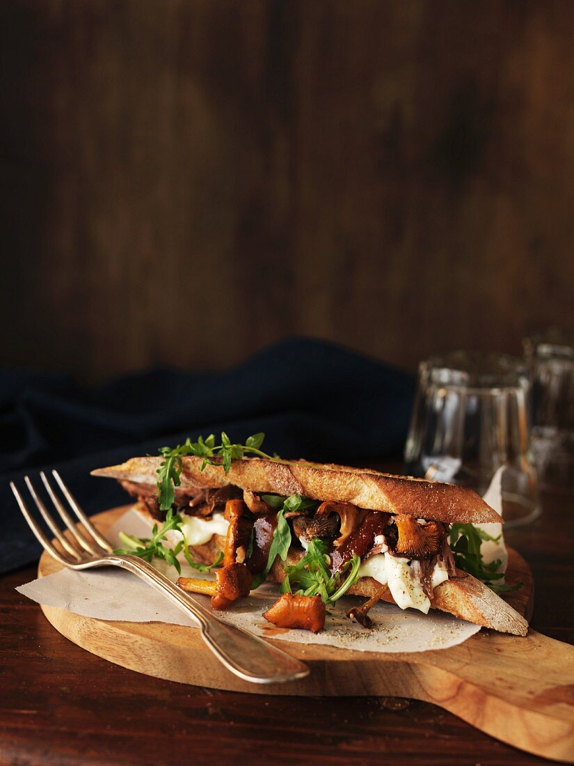A toasted baguette sandwich with chanterelle mushrooms and Brie