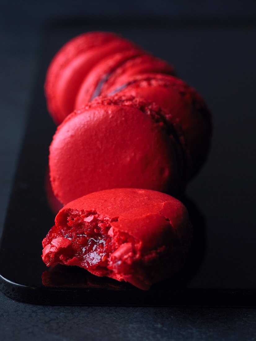 Classic raspberry macaroons, one with a bite taken out