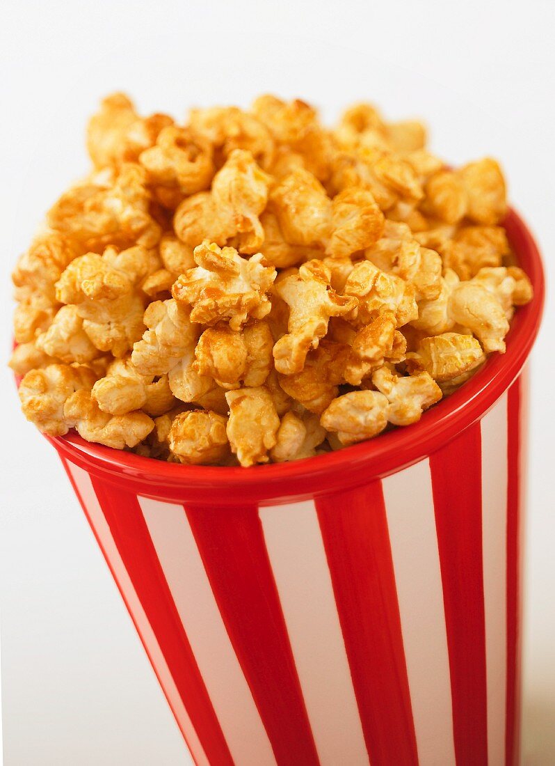Karamell-Popcorn im gestreiften Plastikbecher