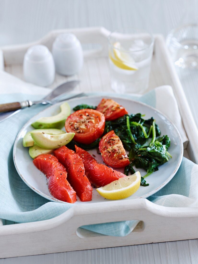 A healthy breakfast of salmon, tomatoes, spinach and avocado