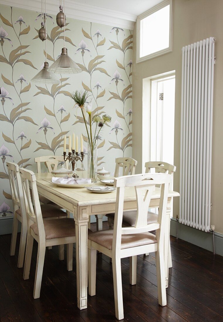 Floral wallpaper behind traditional, white, country-house-style dining set