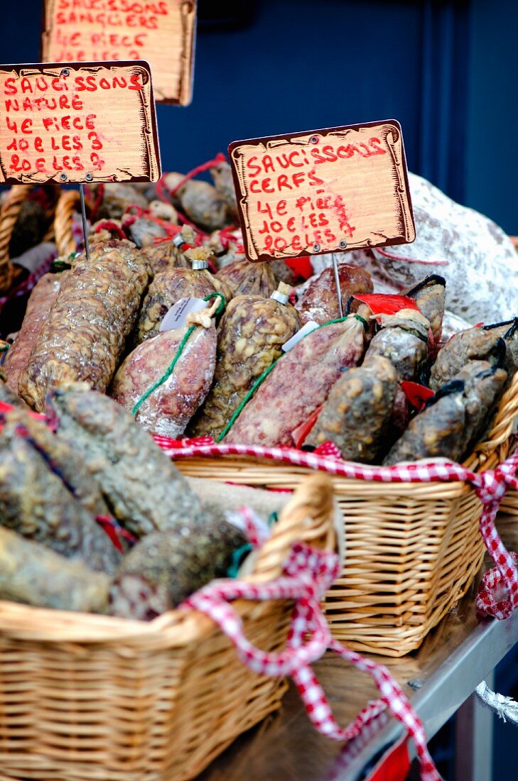 Various types of salami on market stand