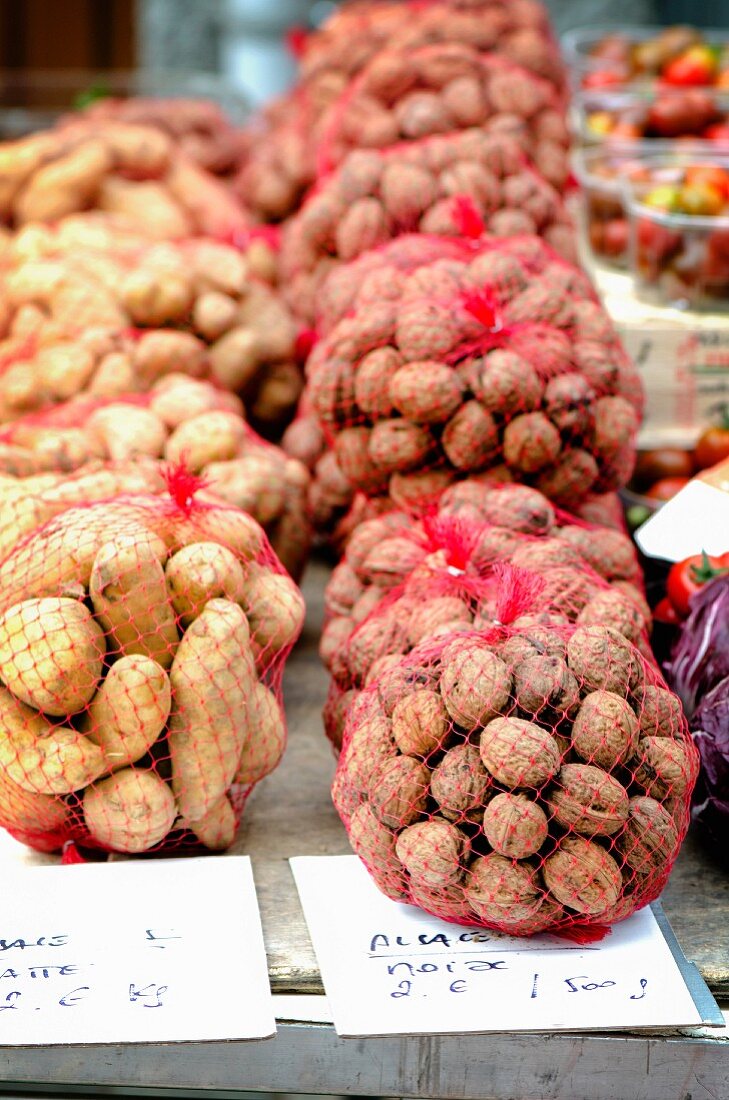 Fresh walnuts and potatoes on a market stand