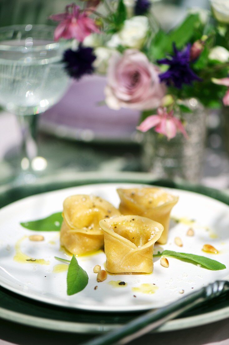 Tortellini with a pumpkin and mustard filling garnished with sage leaves and pine nuts