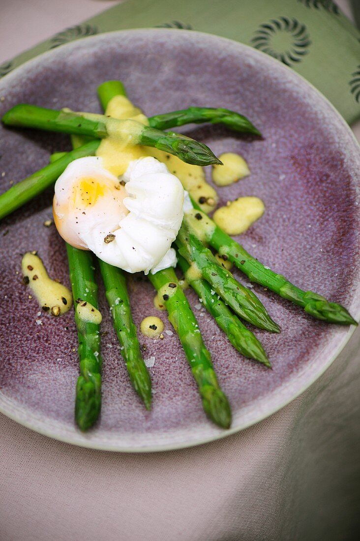A poached egg on green asparagus with a mustard vinaigrette