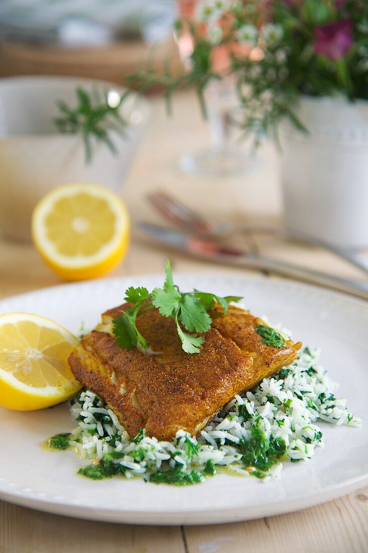 Fried cod fillets with a spicy coating on a bed of coriander rice