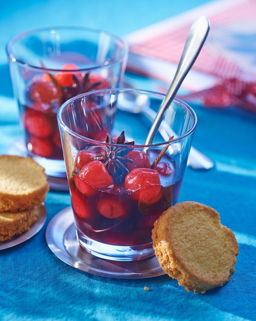 Cherry soup in glasses with star anise and biscuits