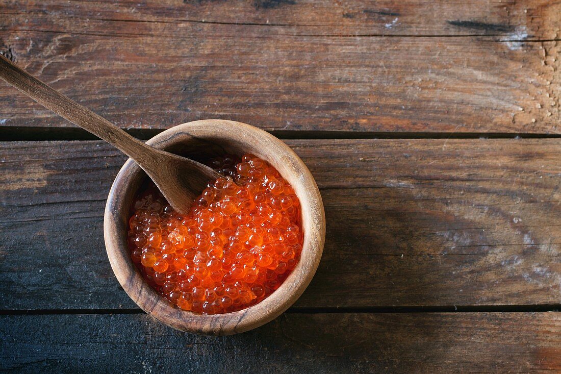 Roter Kaviar in Holzschale mit Löffel