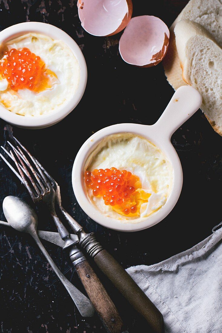 Gebackene Eier mit rotem Kaviar, Brot und altem Besteck