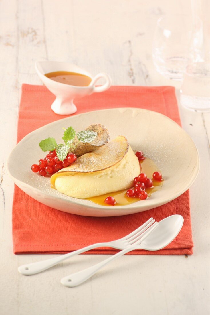 Soufflierte Crepes in Orangensirup mit roten Johannisbeeren und Mohnschindeln