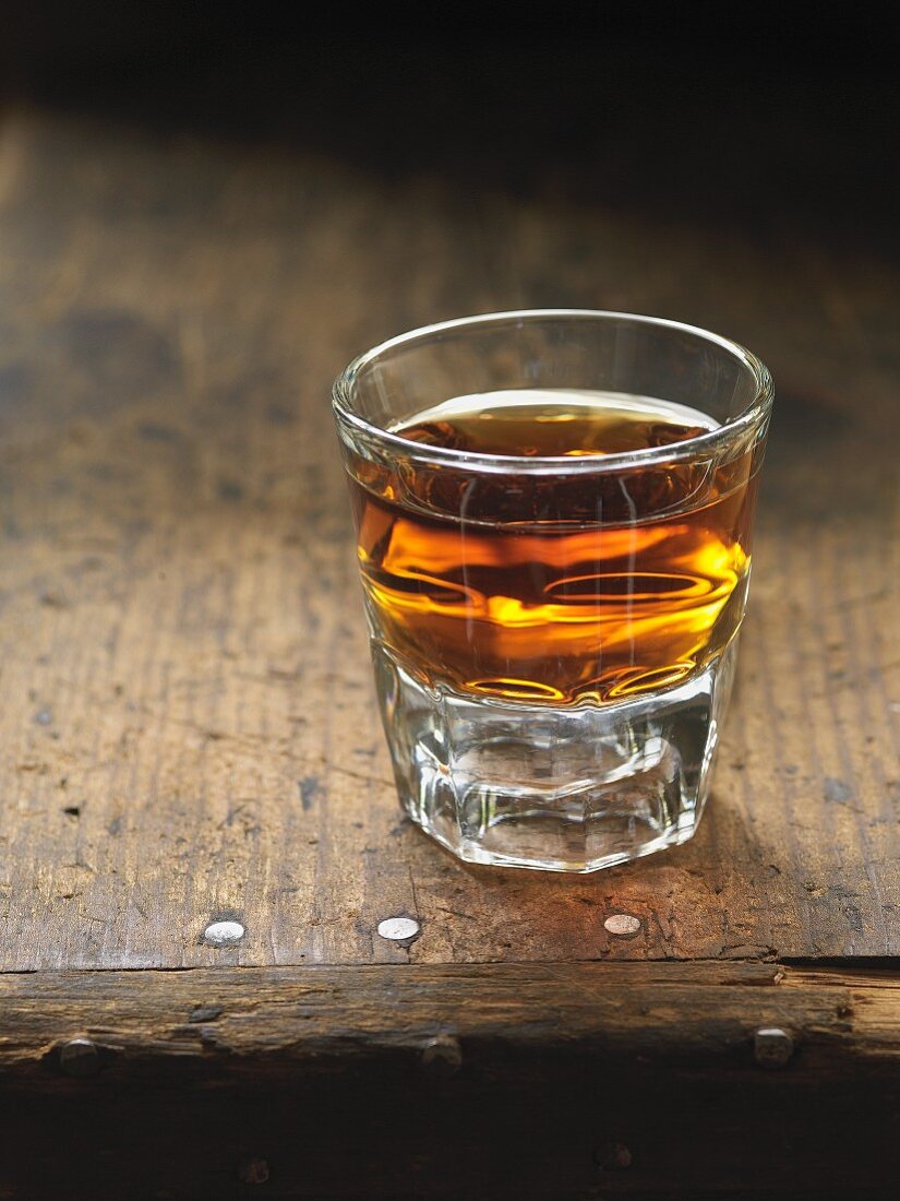 A glass of whisky on a wooden table