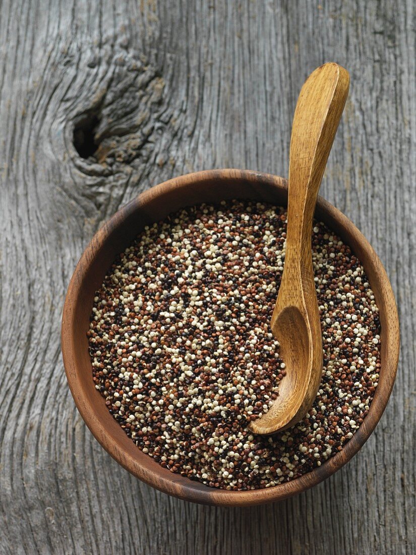 Mixed quinoa in a wooden bowl with a spoon