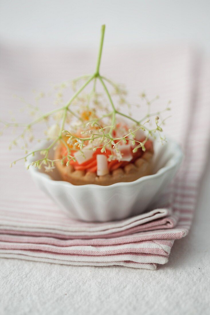 Elderberry and peach tartlet with white chocolate and elderflowers