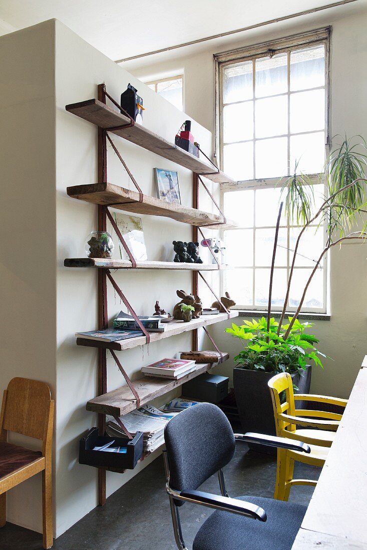 Simple wooden shelves on partition wall in dining area