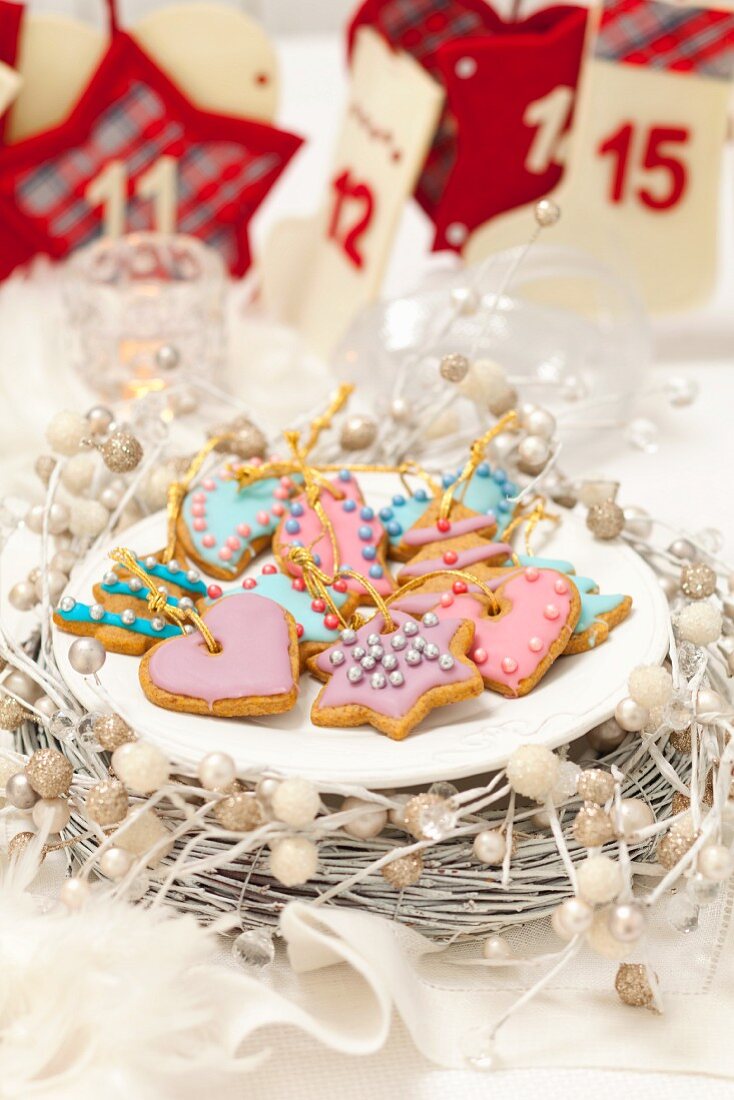 Gingerbread biscuits decorated with pastel coloured icing and sugar pearls