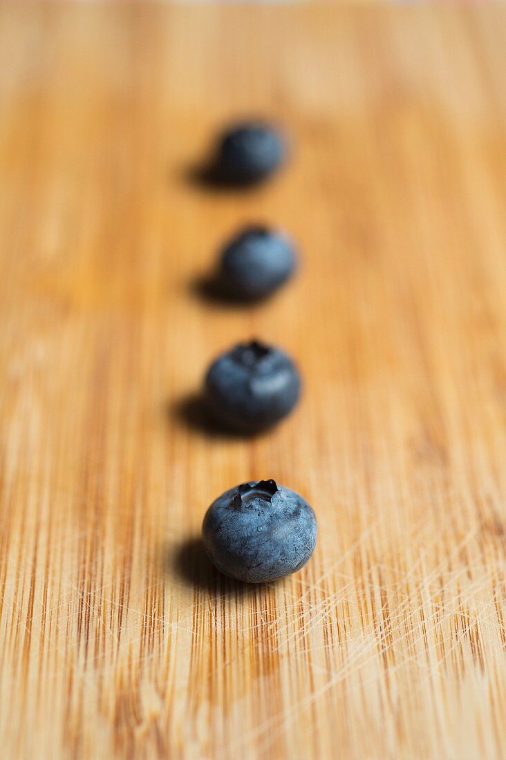 Reihe von Blaubeeren auf Holzuntergrund (Nahaufnahme)