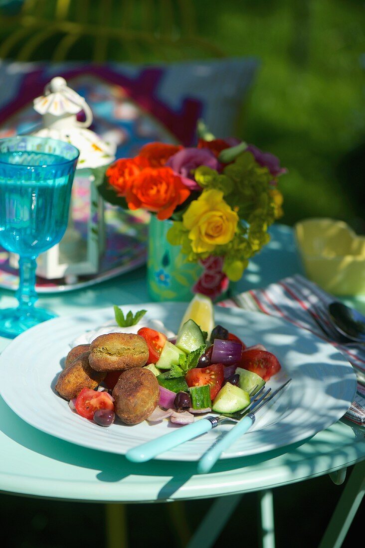 Tomato cucumber salad with fried chickpea balls at a summer party