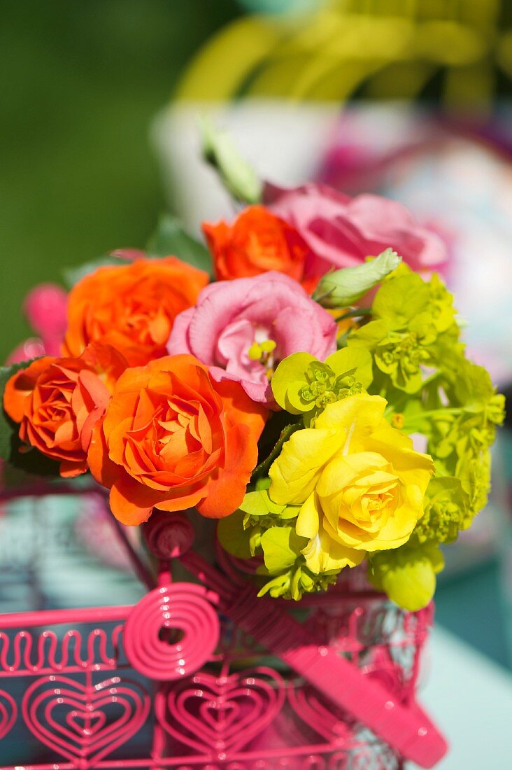 Colourful bouquet in wire basket outdoors