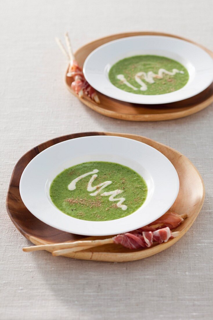 Lettuce soup with dried mushrooms served with grissini and bacon