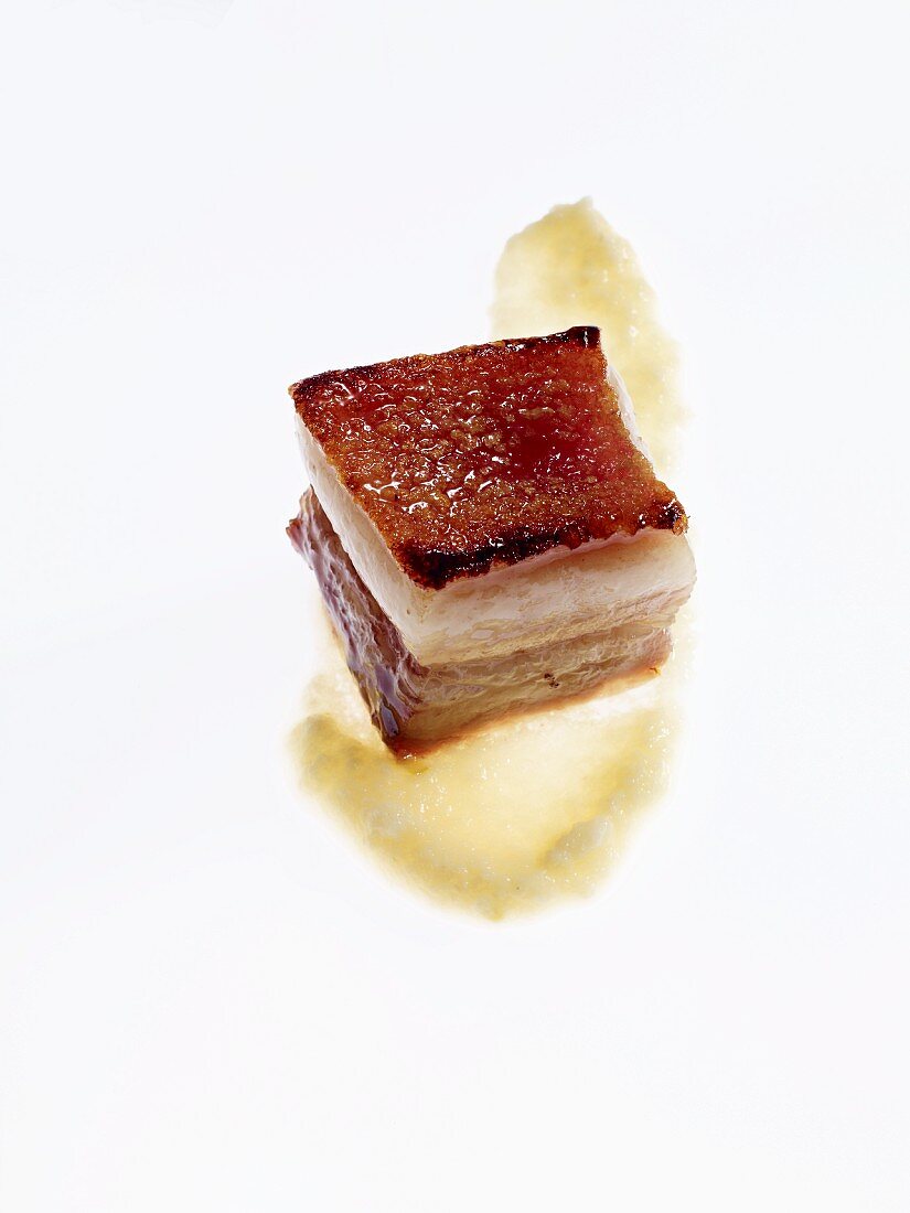 A piece of honey-glazed pork belly with vegetable purity