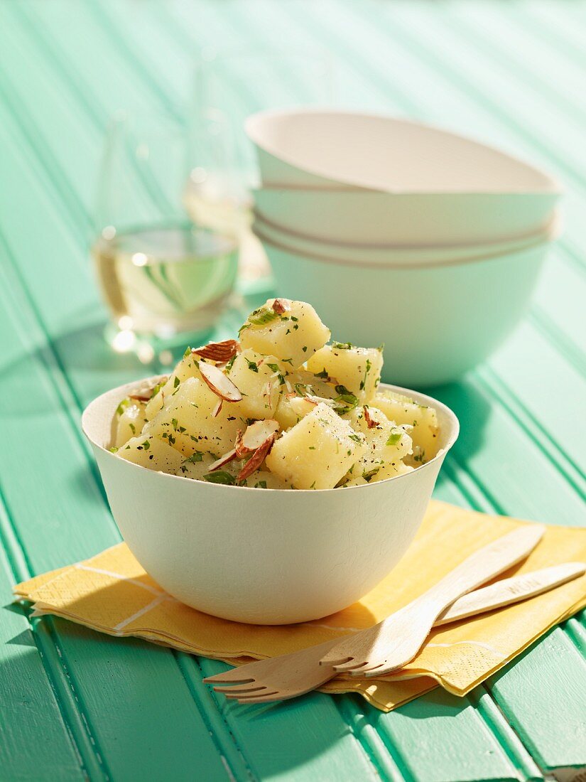 Potato salad with almonds in a wooden bowl for a picnic