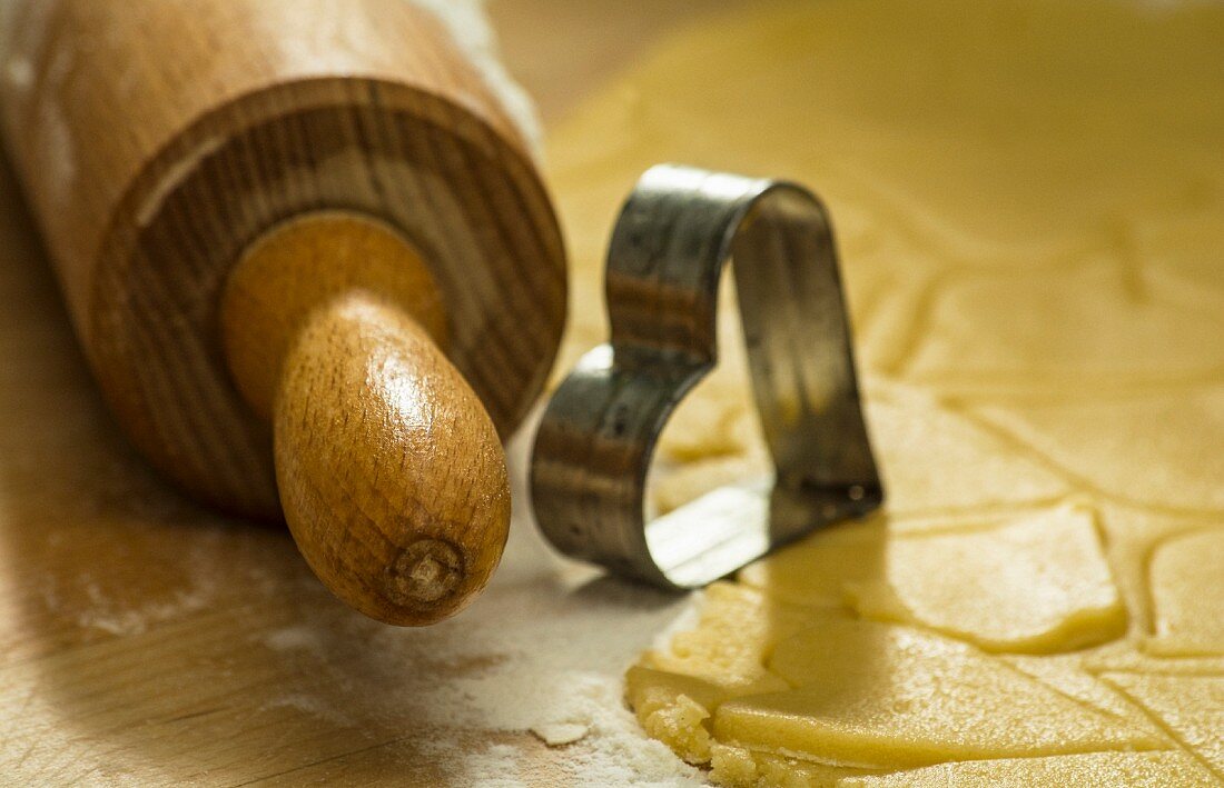 A rolling pin, a cutter and biscuit pastry