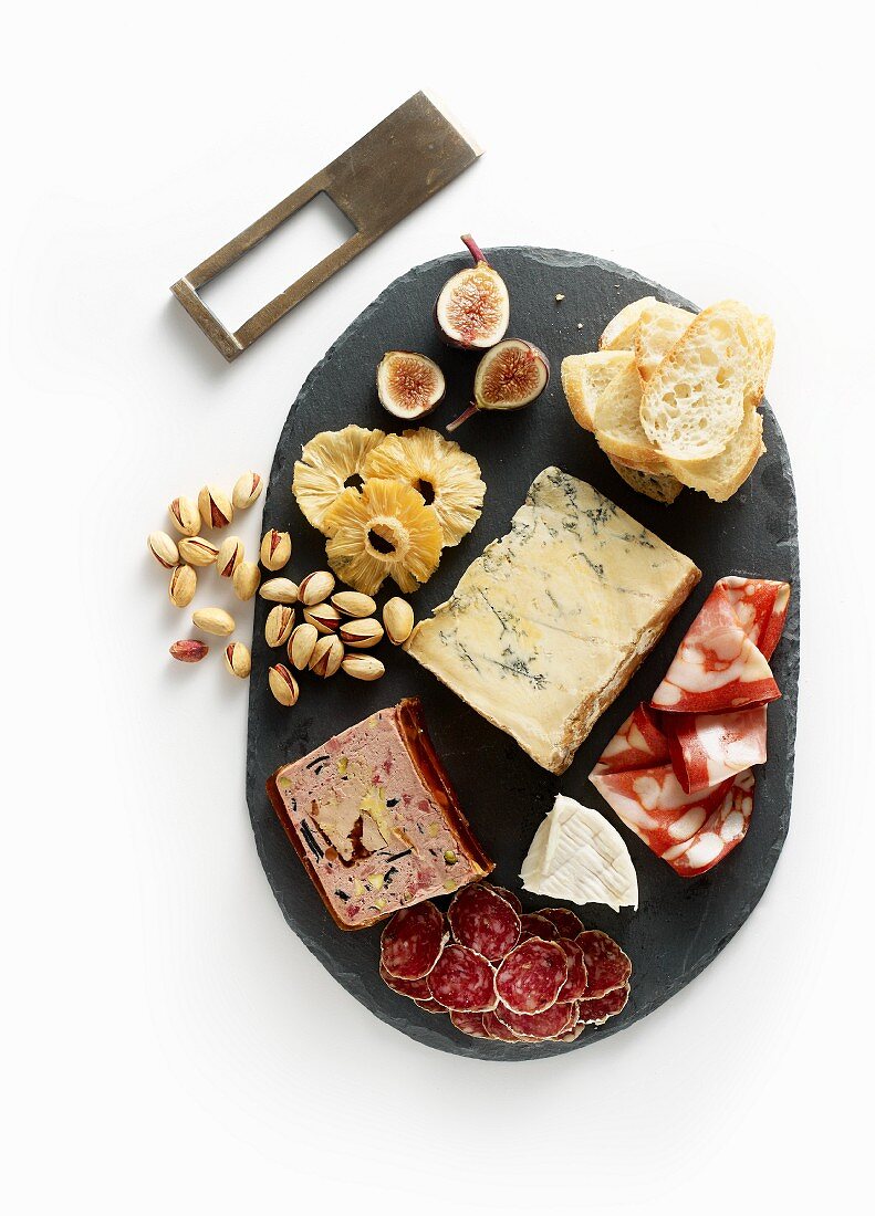 A charcuterie and cheese board with pistachios and fruits